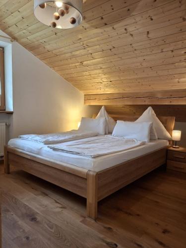 a bedroom with a large bed with a wooden ceiling at Haus Rosamirl Ferienwohnung in Wallgau