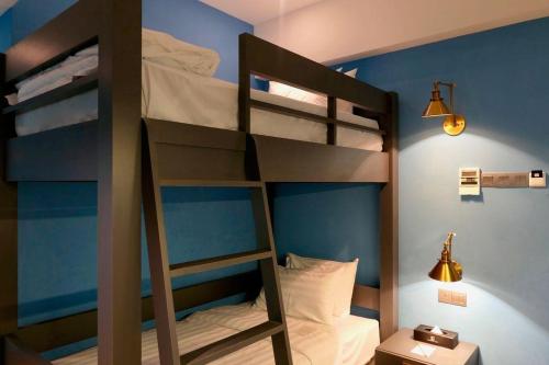 a bunk bed in a room with a ladder at Le Embassy Hotel Georgetown in George Town