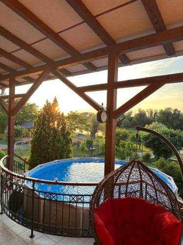a hot tub on a patio with a swing at Vikendica Dva labuda in Banoštor
