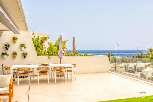a patio with a table and chairs and a view of the ocean at ViVi Homes - Marisol Pool, Sauna, Gym, Spa & Beach in Mijas Costa
