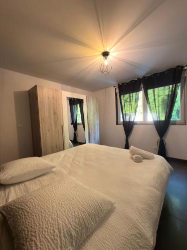 a bedroom with a large white bed with a light at Le 7ème Art in Hombourg-Haut