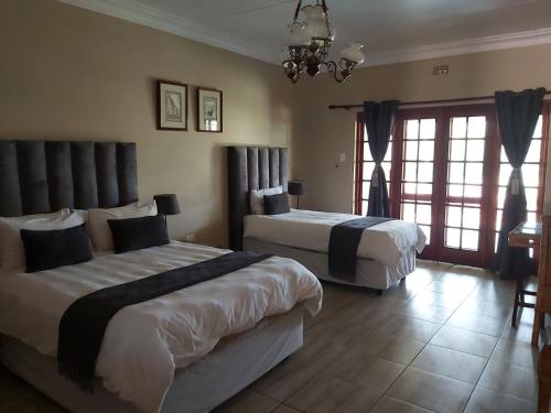a bedroom with two beds and a chandelier at Old Mine Guesthouse in Musina