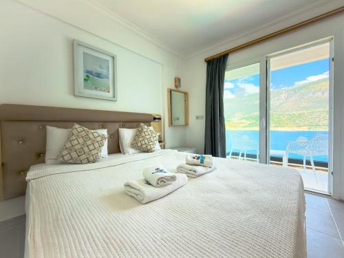 a bedroom with a large bed with towels on it at Korsanada Hotel in Kaş