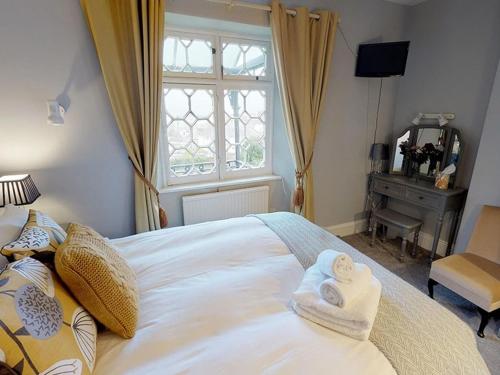 a bedroom with a bed with towels on it at Ranscombe House in Brixham