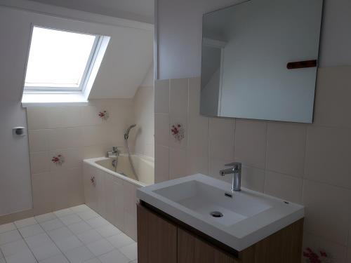 a bathroom with a sink and a tub and a window at Gîte 10 Couchages À Barfleur in Barfleur