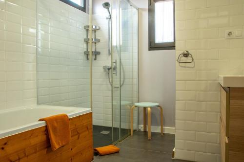 a bathroom with a shower and a tub and a stool at Casa Be in Caleta De Fuste