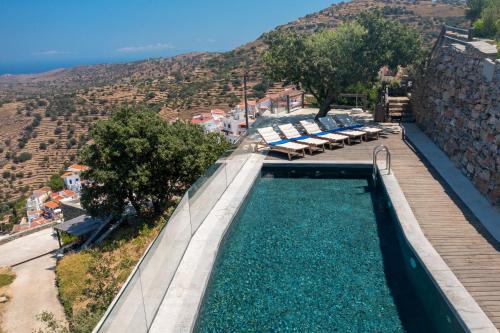 a swimming pool with a view of a mountain at Kea Village Suites & Villas in Ioulis
