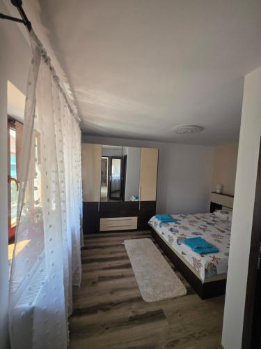 a bedroom with a bed with curtains in it at Mica căsuța in Jurilovca