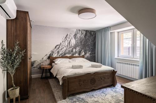 a bedroom with a bed with a mountain mural on the wall at JW Apartments in Krościenko