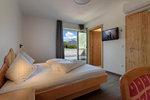 a bedroom with a bed and a large window at Chalet Anna in Marlengo