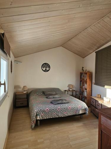 a bedroom with a bed and a clock on the wall at Les Renaudelles in Angles