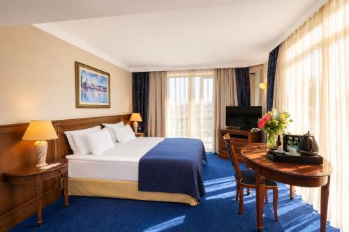 a hotel room with a bed and a desk and a television at Crystal Palace Boutique Hotel in Sofia