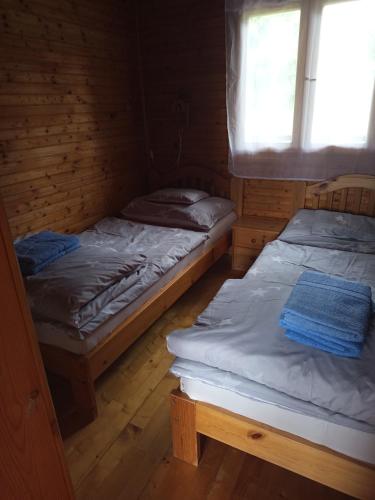 two twin beds in a room with a window at Romantyk vendégház in Mánfa