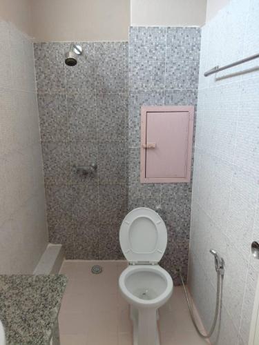 a bathroom with a toilet and a shower with a pink box at Metro Residence in Surin