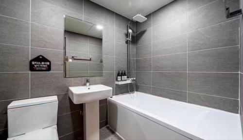 a bathroom with a sink and a tub and a toilet at Daily Motel in Incheon