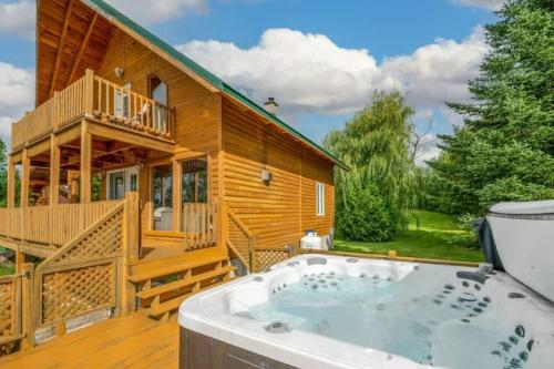a large wooden house with a hot tub on a deck at Spa Pool table Mountain view - Martine-54 in Petite-Rivière-Saint-François