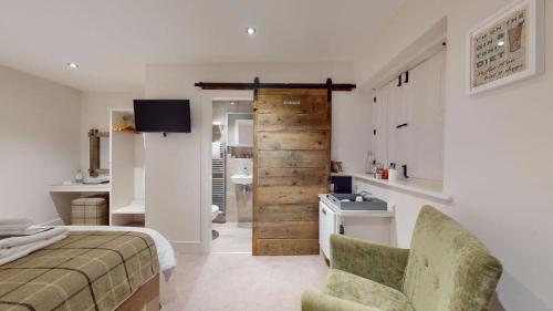 a bedroom with a bed and a bathroom with a sink at The Devonshire Arms in Eckington
