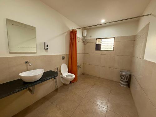 a bathroom with a sink and a toilet at Hotel Marigold Vasad in Vāsad