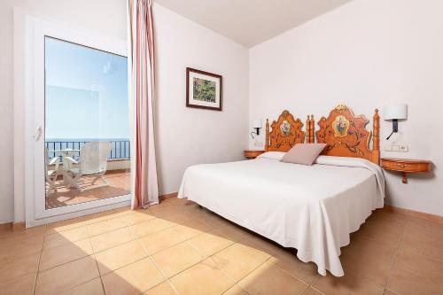 ein Schlafzimmer mit einem großen Bett und einem Balkon in der Unterkunft Hotel Sant Roc in Calella de Palafrugell