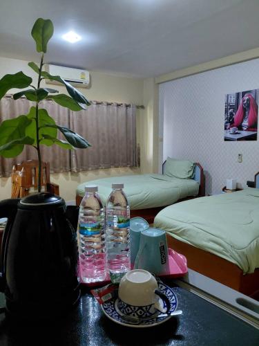 a room with two beds and two bottles of water on a table at Metro Residence in Surin
