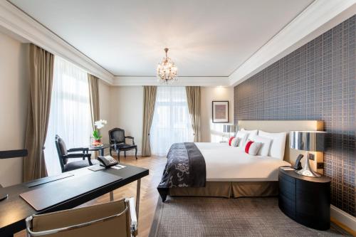 a hotel room with a bed and a desk at Hotel Schweizerhof Bern & Spa in Bern
