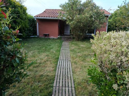 a brick path leading to a red house at Appartement Mugron in Mugron
