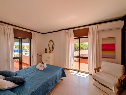 a bedroom with a blue bed and a chair at 06 Sra da Rocha - Casas & Papeis in Porches