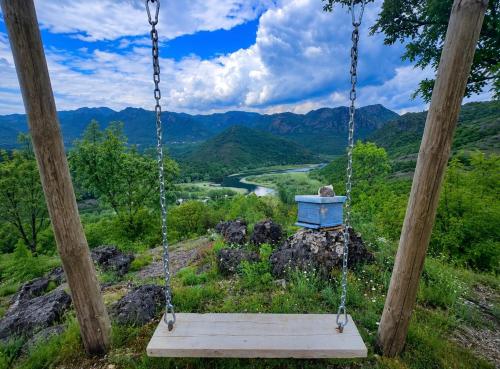 a swing with a view of a river at S&M Apartments in Rijeka Crnojevića