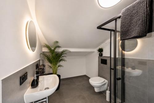a bathroom with a sink and a toilet at Nordbrise by BohnApartments-Modernes Apartment-Zentrum Diepholz-Parken kostenfei in Diepholz