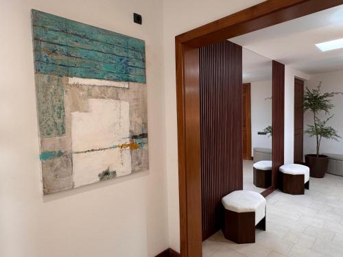 a hallway with a painting on the wall and two stools at Villa Dedalos - Spacious luxury Villa with heated pool in Puerto Calero in Puerto Calero