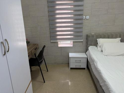 a bedroom with a bed and a desk and a window at Laila's studio in Haifa