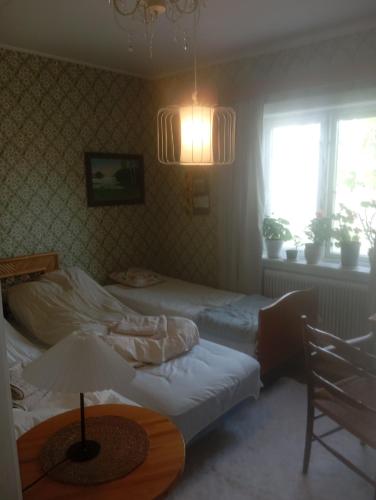a bedroom with two beds and a table with a lamp at Guest Room in Liviöjärvi
