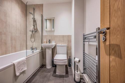 a bathroom with a toilet and a sink and a tub at Stylish Flat in the City Centre - Pass the Keys in Portsmouth