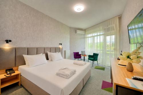ein Schlafzimmer mit einem großen weißen Bett und einem Tisch in der Unterkunft Augusta SPA Hotel in Chissarja