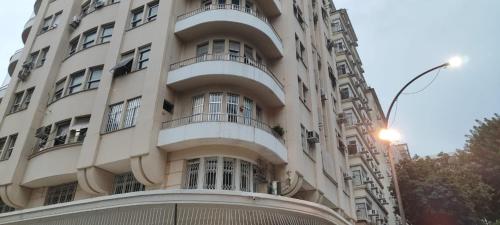 a tall white building with balconies and a street light at Studio SDU Aeroporto VLT Metrô Cinelândia in Rio de Janeiro