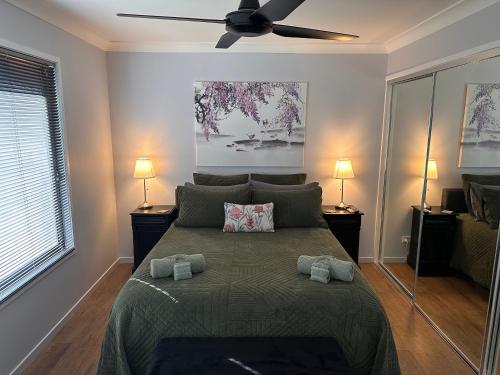 a bedroom with a bed with a ceiling fan at Among The Trees Guest Suite in Kooralbyn