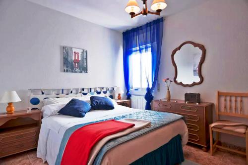ナヴァルカルネロにあるIberia TM Apartments Real Villaのベッドルーム(大型ベッド1台、鏡付)