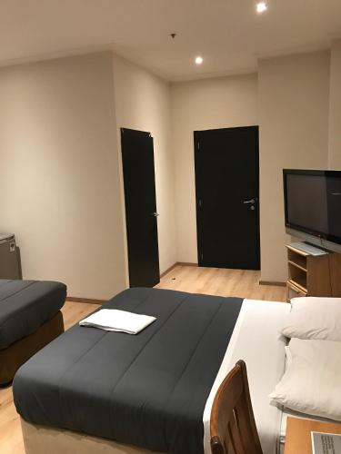 a bedroom with two beds and a flat screen tv at Royal Hotel in Brussels
