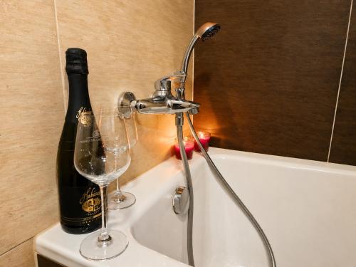 a bottle of champagne and a wine glass in a bath tub at Podbrdská chalupa in Nechanice