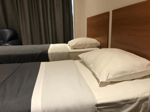 two beds in a hotel room with white sheets and pillows at Royal Hotel in Brussels