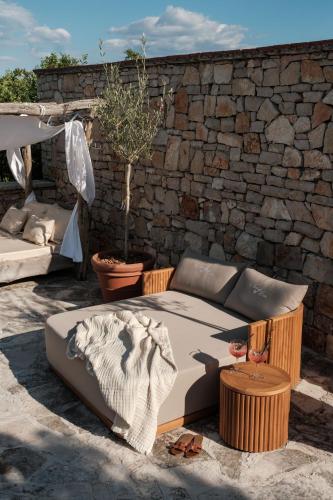 a bed sitting next to a brick wall at Nono Ban Boutique Hotel & Villas in Gornji Humac
