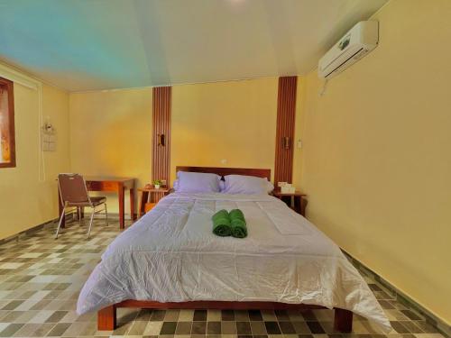 a bedroom with a bed with green shoes on it at Amaro Homestay in Nuhu Tawun