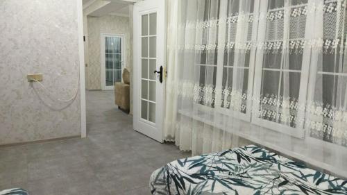 a room with a bed and a door with curtains at TamoLand in Astara
