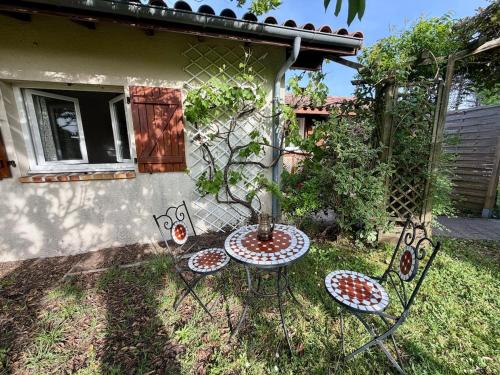 a garden with a table and chairs in the grass at Maisonnette près du lac in Léon