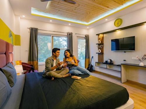 a man and a woman sitting on a bed at The Hosteller Lansdowne in Lansdowne