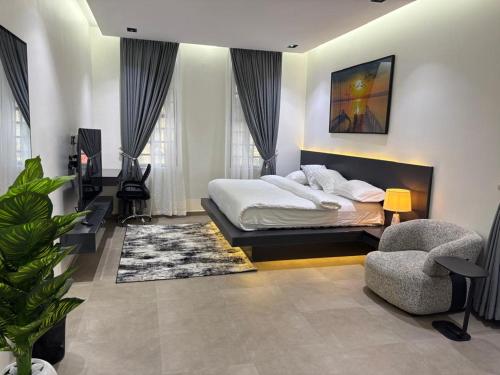 a bedroom with a bed and a chair at Reign Residence in Port Harcourt