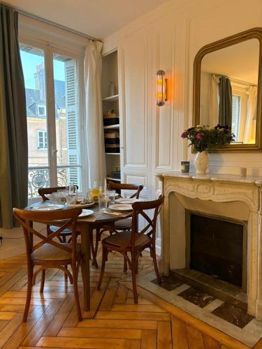 a dining room with a table and a fireplace at Peaceful haven in Honfleur