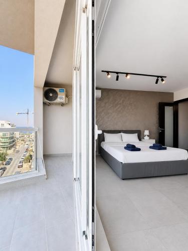 a bedroom with a bed and a balcony at Prestigious & Modern SeaView Penthouse with Private Jacuzzi in Marsaskala
