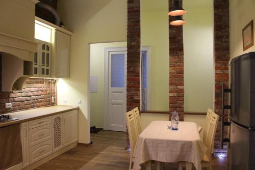 a kitchen with a table with chairs and a refrigerator at Apartment Novyj Svit in Lviv