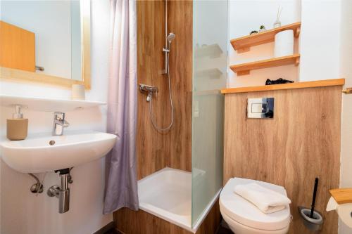 a bathroom with a shower and a sink and a toilet at Meeresbrise in Thiessow